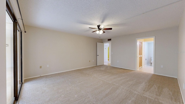 carpeted spare room featuring a textured ceiling and ceiling fan