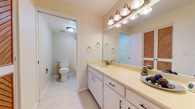 bathroom featuring tile patterned floors, double vanity, and toilet