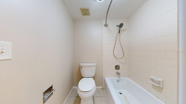 bathroom featuring tile patterned floors, tiled shower / bath, and toilet