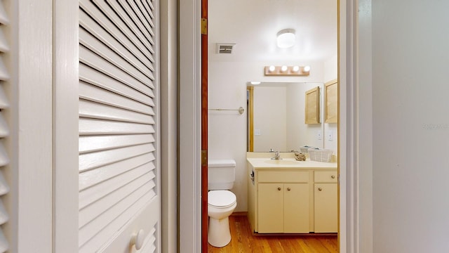 bathroom featuring toilet, hardwood / wood-style floors, and vanity