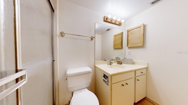 bathroom with a shower with door, toilet, and vanity