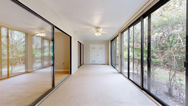 unfurnished sunroom with ceiling fan