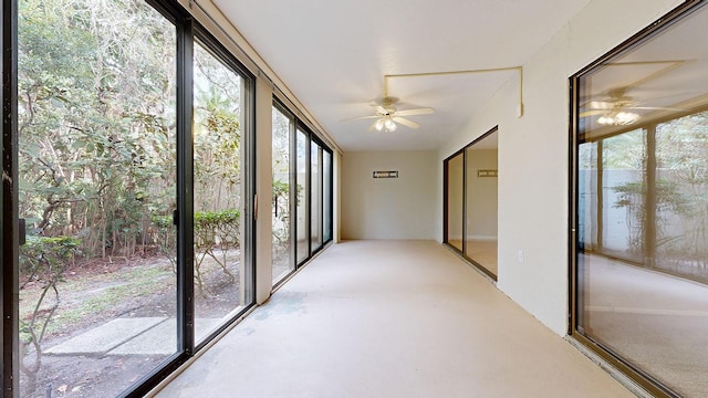 unfurnished sunroom with ceiling fan