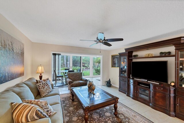 tiled living room with ceiling fan and a textured ceiling