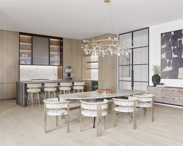 dining room featuring light wood-type flooring and a chandelier