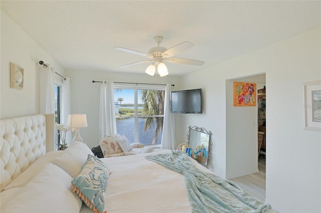 bedroom featuring ceiling fan, a textured ceiling, and wood finished floors