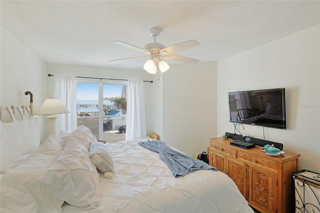 bedroom with ceiling fan and a textured ceiling