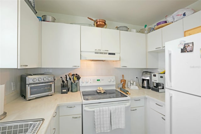 kitchen with white appliances, under cabinet range hood, light countertops, and backsplash