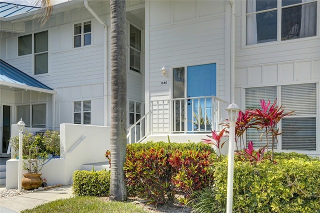 entrance to property featuring board and batten siding, a standing seam roof, and metal roof