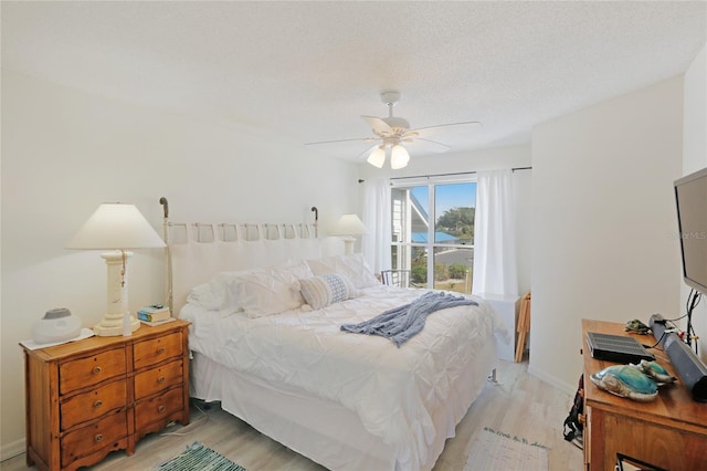 bedroom featuring a textured ceiling, ceiling fan, and light hardwood / wood-style floors