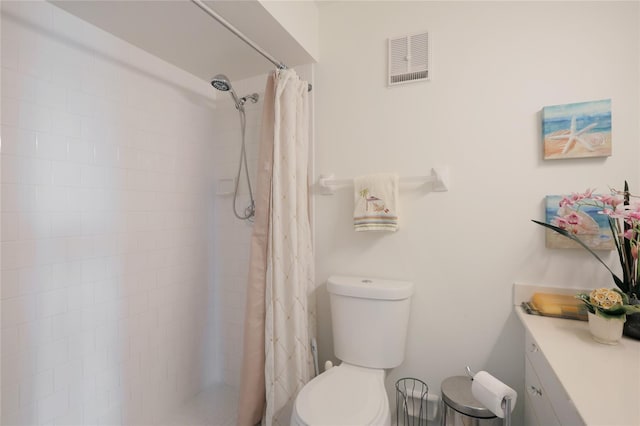 bathroom featuring vanity, toilet, and curtained shower