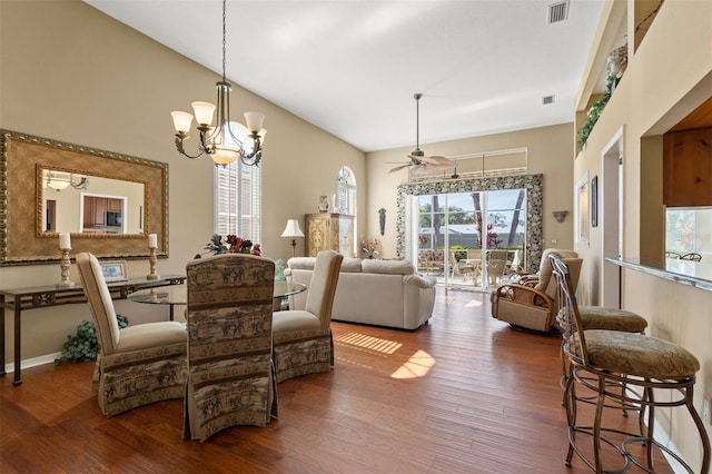 dining room featuring ceiling fan with notable chandelier and dark wood-type flooring