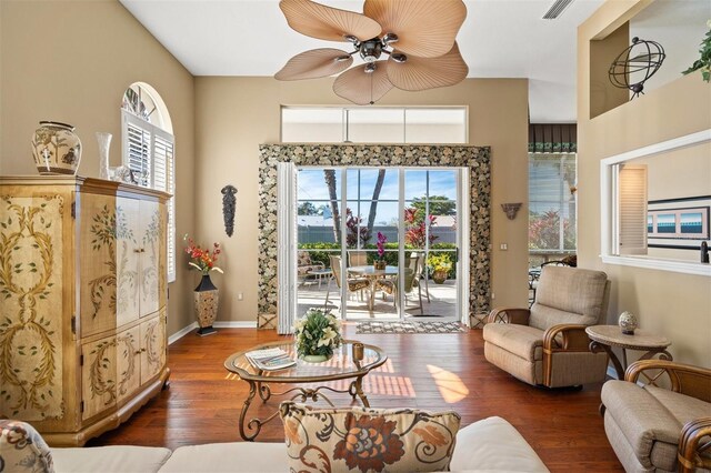 living room featuring ceiling fan, dark hardwood / wood-style flooring, and a healthy amount of sunlight