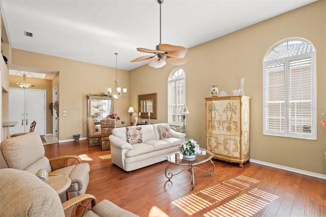 living room with ceiling fan with notable chandelier, hardwood / wood-style floors, and a wealth of natural light