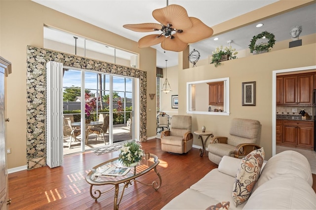 living room featuring ceiling fan, dark hardwood / wood-style floors, and a high ceiling