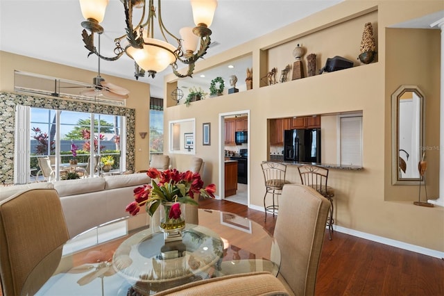 dining space featuring ceiling fan with notable chandelier and hardwood / wood-style flooring