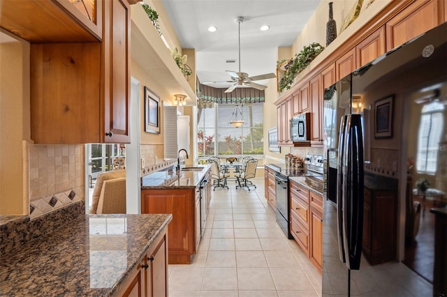 kitchen with stainless steel microwave, black fridge with ice dispenser, backsplash, ceiling fan, and range with electric stovetop