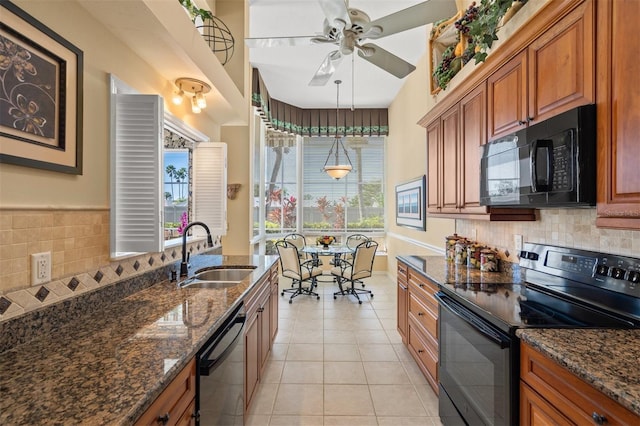 kitchen featuring black appliances, sink, light tile patterned floors, and a healthy amount of sunlight