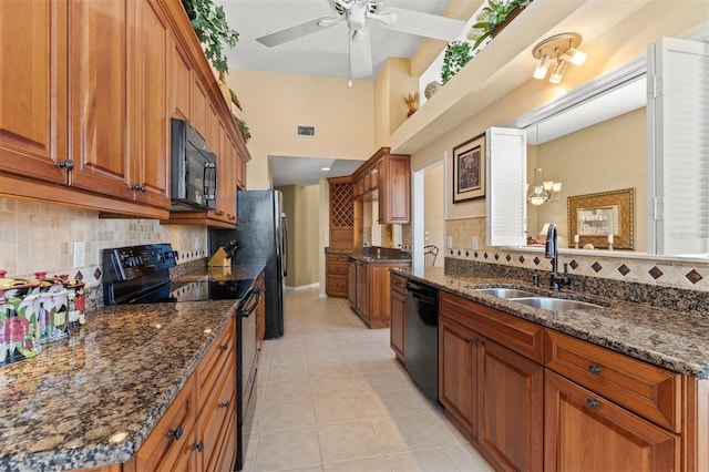 kitchen featuring decorative backsplash, ceiling fan with notable chandelier, black appliances, light tile patterned floors, and sink