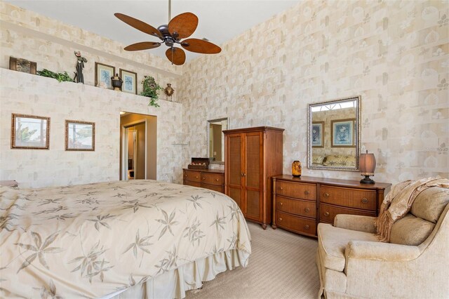 bedroom featuring ceiling fan, a towering ceiling, and light carpet