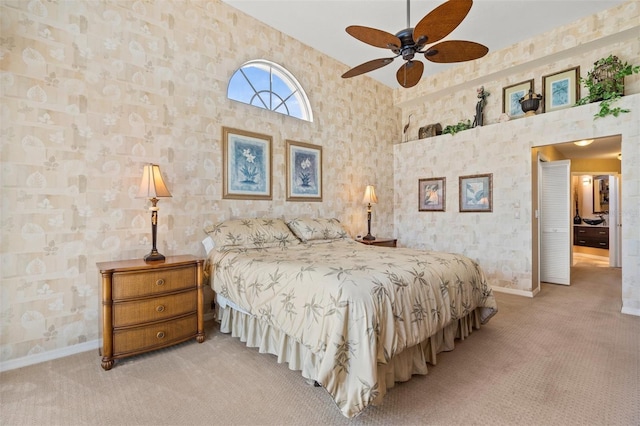 bedroom with ceiling fan, a towering ceiling, and light colored carpet