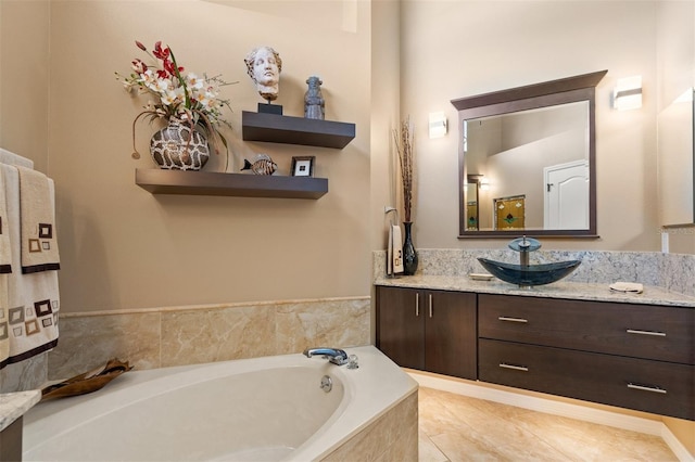 bathroom with tile patterned floors, vanity, and tiled tub