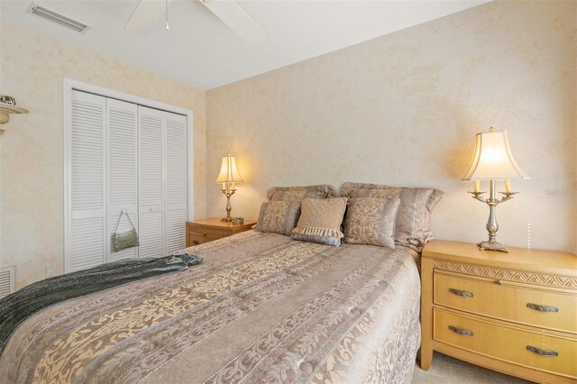 carpeted bedroom featuring ceiling fan and a closet