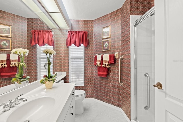 bathroom with vanity, toilet, a shower with door, and tile patterned flooring