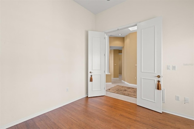 unfurnished room with hardwood / wood-style flooring