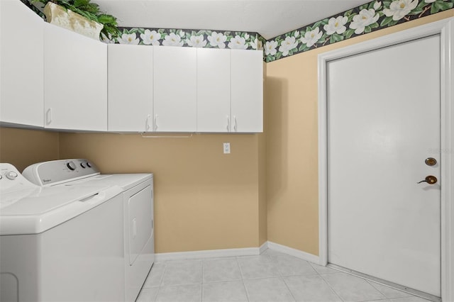 laundry area with cabinets, washing machine and dryer, and light tile patterned floors