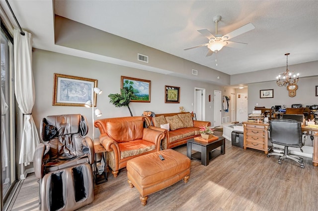 living room with light hardwood / wood-style flooring and ceiling fan with notable chandelier