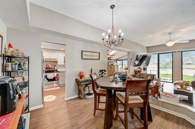 dining room featuring light hardwood / wood-style floors, a textured ceiling, and ceiling fan with notable chandelier