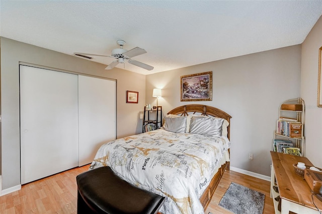 bedroom featuring a closet, a textured ceiling, ceiling fan, and light hardwood / wood-style flooring