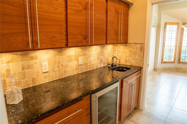 kitchen featuring light tile patterned flooring, sink, dark stone countertops, beverage cooler, and decorative backsplash