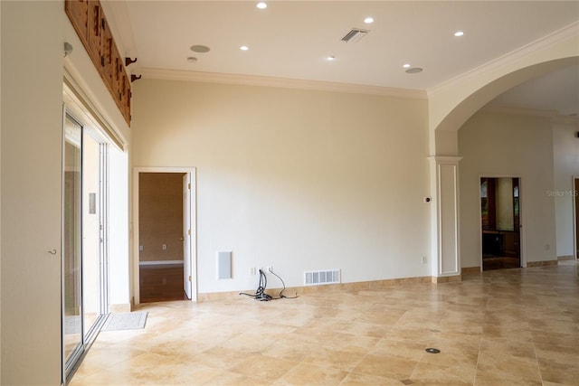 empty room with crown molding and a towering ceiling