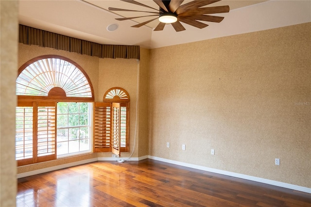 unfurnished room featuring ceiling fan, hardwood / wood-style floors, and a high ceiling