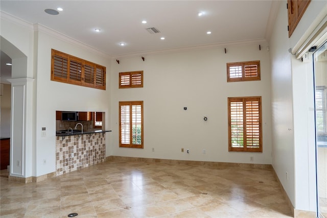 living room featuring ornamental molding and a towering ceiling