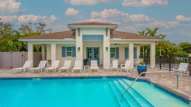 rear view of house featuring ceiling fan, a community pool, and a patio