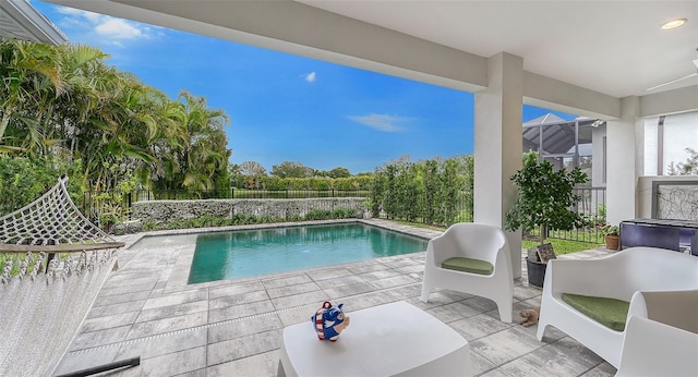 view of pool featuring glass enclosure and a patio area