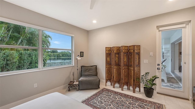 living area with a water view and light tile patterned floors