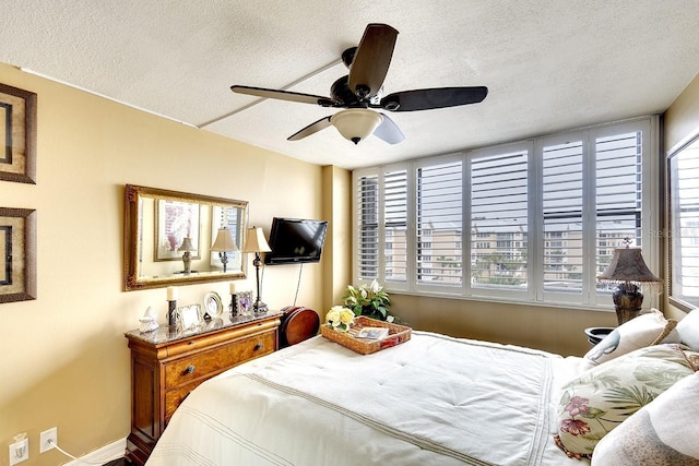 bedroom with a textured ceiling and ceiling fan