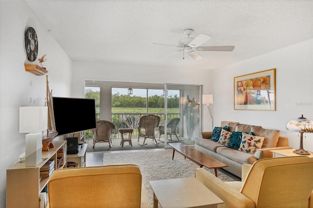 carpeted living room with ceiling fan and a textured ceiling