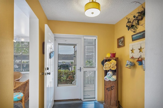 doorway to outside featuring a textured ceiling and a wealth of natural light