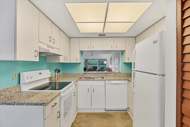 kitchen with white appliances, white cabinets, light stone counters, and sink