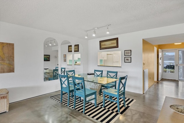 dining room featuring track lighting and a textured ceiling