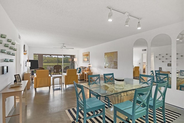 dining area with a textured ceiling, ceiling fan, and rail lighting