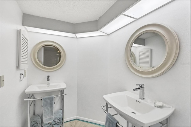 bathroom featuring a textured ceiling, wood-type flooring, and sink