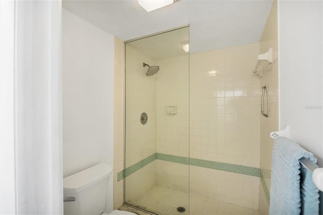 bathroom with toilet and a shower with shower door