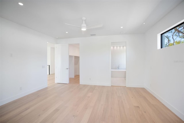 unfurnished bedroom featuring light wood-type flooring, a spacious closet, baseboards, and recessed lighting