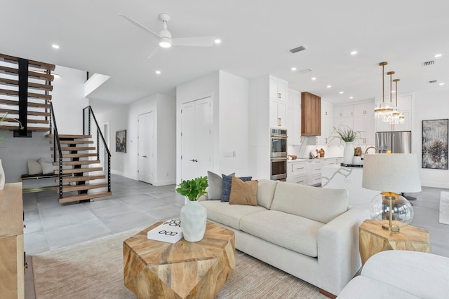 living area with stairway, ceiling fan with notable chandelier, visible vents, and recessed lighting